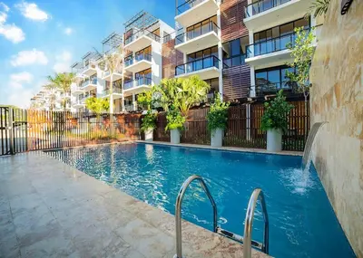 a swimming pool in front of a building at Divine Stay 3 Bedroom One minute from the beach on the malecon in San Felipe de Puerto Plata