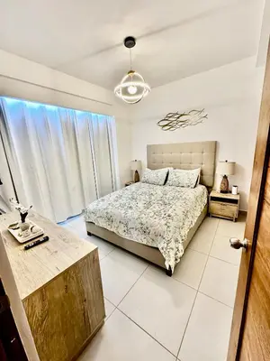 a bedroom with a bed and a large window at Acogedor Apartamento en JUAN DOLIO in Los Corrales