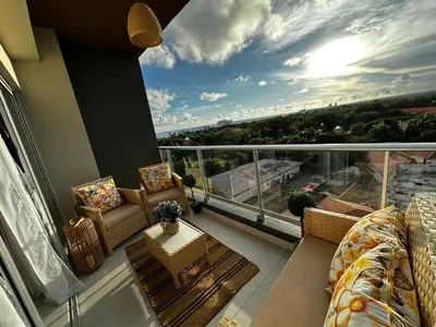 a balcony with a couch and chairs and a table at Acogedor Apartamento en JUAN DOLIO in Los Corrales