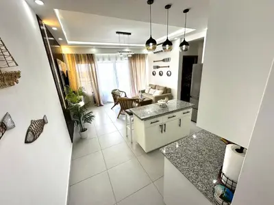 a kitchen and living room with a table and a couch at Acogedor Apartamento en JUAN DOLIO in Los Corrales