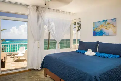 a bedroom with a blue bed with a view of the ocean at KITE BEACH HOTEL Oceanfront Apartments in Cabarete