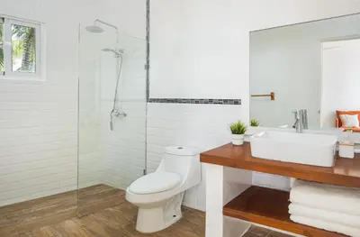 a white bathroom with a toilet and a sink at KITE BEACH HOTEL Oceanfront Apartments in Cabarete