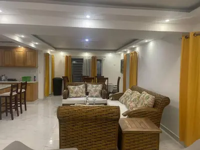 a living room with a couch and chairs and a kitchen at Modern House in Santo Domingo Este in Juan López
