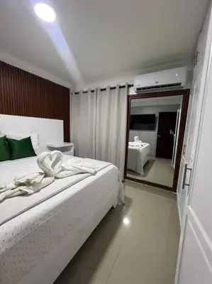 a bedroom with a white bed and a large mirror at Encantador y lujoso apartamento in San Pedro de Macorís