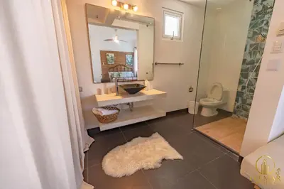 a bathroom with a sink and a mirror and a toilet at Brisas del norte in Sosúa