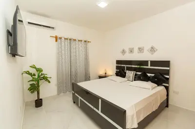 a bedroom with a large bed and a tv at Crown lll with Pool -3 Bedrooms close to Everything in Puerto Plata