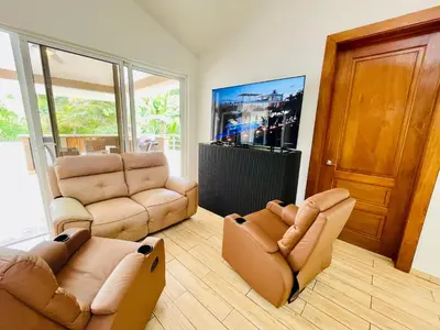 a living room with two chairs and a couch and a tv at Casa feliz in Sosúa