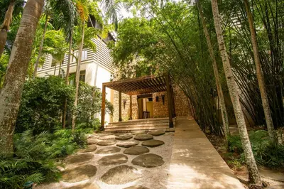 a garden with a pathway leading to a house at Apto en Casa de Campo en Los Altos 2 in La Romana
