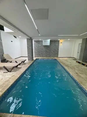 a large swimming pool with blue water in a building at Apartment in Santo Domingo este in Juan López