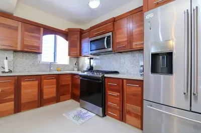 a kitchen with wooden cabinets and a stainless steel refrigerator at Edificio Amber 1 in San Cristóbal