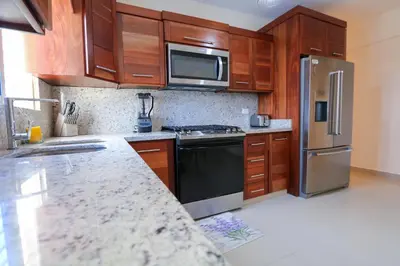 a kitchen with stainless steel appliances and wooden cabinets at Edificio Amber 1 in San Cristóbal