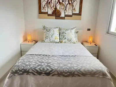 a bedroom with a bed with two lamps on tables at AD-301 Ático Duplex Estrella Dominicus in La Laguna