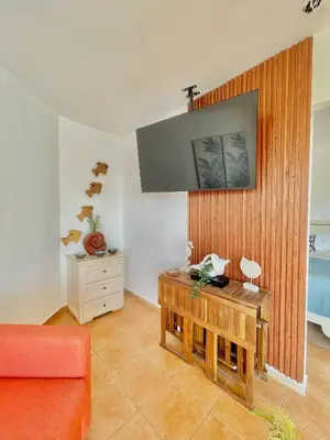 a living room with a table and a tv at Estancia Nana apartamento vista al mar piscina WIFI cocina completa aire acondicionado Lavadora secadora in Juan Dolio