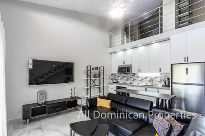 a living room with a couch and a tv at Hill Side Condos - Hispaniola in Sosúa