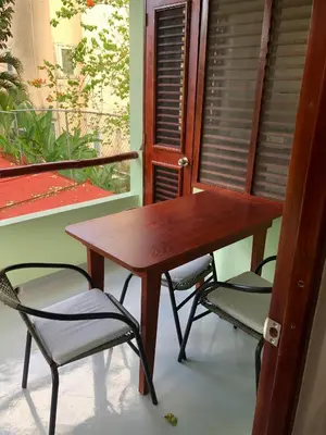a wooden table and chairs on a balcony at Hotel Casa Robinson in Las Terrenas