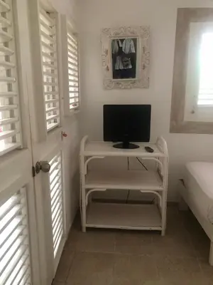 a computer monitor on a desk in a room with windows at Hotel Casa Robinson in Las Terrenas