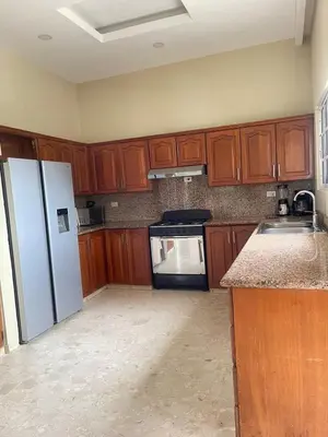 a kitchen with wooden cabinets and a white refrigerator at Villa familiar con vista al océano in San Felipe de Puerto Plata