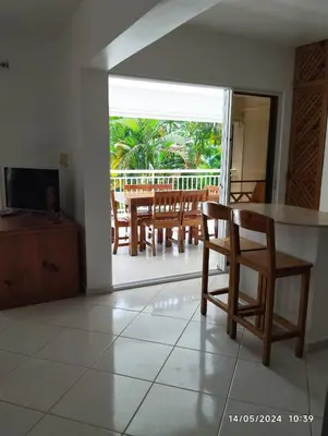 a living room with a table and chairs and a balcony at Residencial caoba in Las Terrenas