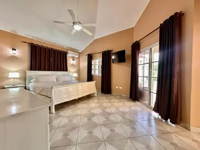 a bedroom with a bed and a ceiling fan at Casa Linda Club in Sosúa