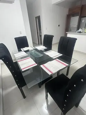 a dining room table with black chairs and a glass table at New Beachfront at Sunset Apartments 3 Bedroom 2 Bath Gym Pool PS5 in San Felipe de Puerto Plata