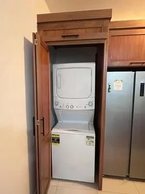 a kitchen with a refrigerator and a microwave at New Beachfront at Sunset Apartments 3 Bedroom 2 Bath Gym Pool PS5 in San Felipe de Puerto Plata