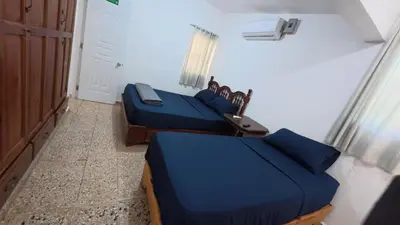 two beds in a room with blue sheets at Villa Cordero - Las Calderas Bani in Baní