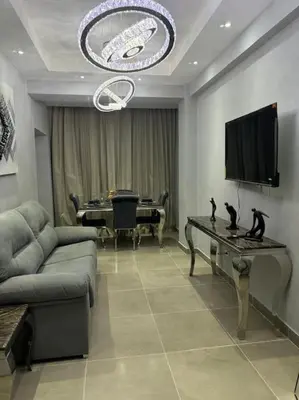 a living room with a couch and a table with a television at Apartamento santo domingo este in Juan López