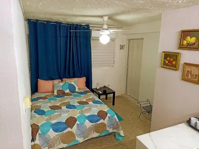 a bedroom with a bed and a blue curtain at Habitacion en el centro in La Julia