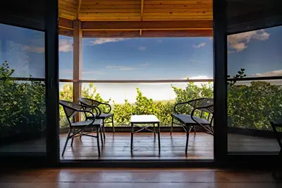 a group of chairs sitting on a screened in porch at The Grand Forest Jarabacoa in Jarabacoa