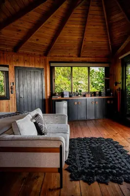 a living room with a couch and a kitchen at The Grand Forest Jarabacoa in Jarabacoa
