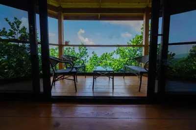 a room with a table and chairs on a balcony at The Grand Forest Jarabacoa in Jarabacoa