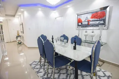 a dining room with a table and blue chairs at Lujoso y confortable apartamento en Santo Domingo in Santo Domingo