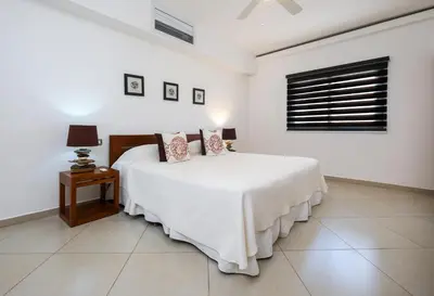 a white bedroom with a bed and a window at Aligio Aparthotel, Beachfront, Las Terrenas in Las Terrenas