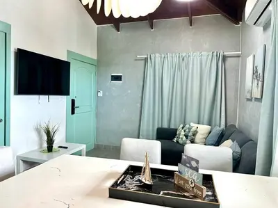 a living room with a couch and a tv at Luperon candles apartment in Puerto de Luperon