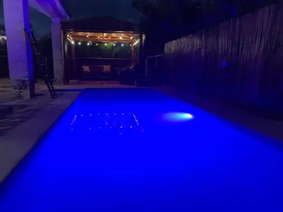 a swimming pool lit up with blue lights at night at Villa en boca chica in Cuevas