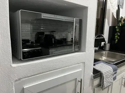 a kitchen with a counter and a sink and a microwave at Cozy Apartment in the heart of Santiago in Santiago de los Caballeros