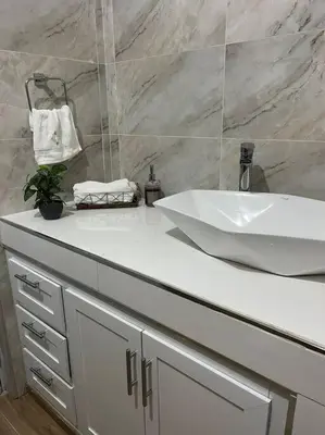 a bathroom with a white sink and a white counter at Cozy Apartment in the heart of Santiago in Santiago de los Caballeros