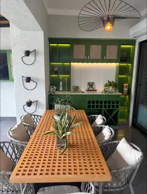 a wooden table and chairs with a green wall at Arpel 6 SantoDomingo CItySeaView in Santo Domingo