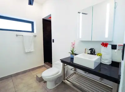 a bathroom with a white toilet and a sink at Infiniti Blu in Sosúa