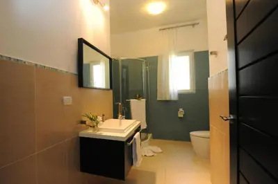 a bathroom with a sink and a toilet and a mirror at Infiniti Blu in Sosúa