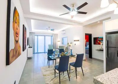 a dining room and living room with a ceiling fan at Infiniti Blu in Sosúa