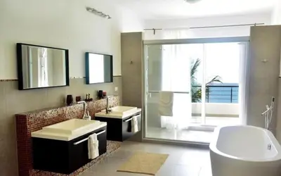 a bathroom with two sinks and a tub and a window at Infiniti Blu in Sosúa