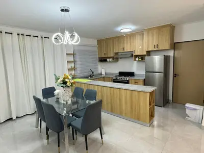 a kitchen with a table with chairs and a refrigerator at RESIDENCIAL LEGADO Apto 1 A in Azua