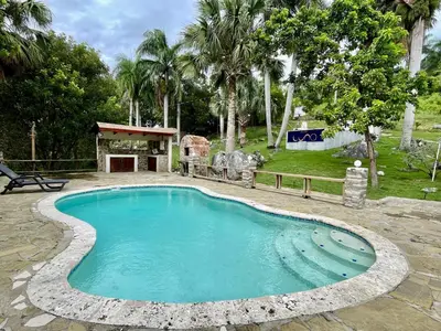 a swimming pool with a stone walkway around it at Exclusive Mountain Villa with Ocean View near Puerto Plata in Maimón