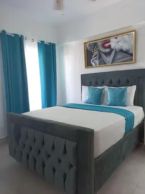 a bedroom with a large bed with blue curtains at Boca del Mar III, apto 707 in Boca Chica