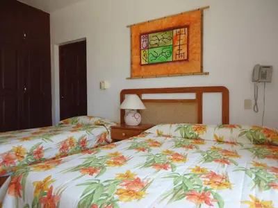 a bedroom with two beds and a picture on the wall at Hotel Angel Gabriel in Boca Chica