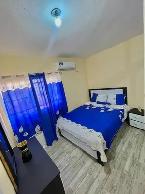 a bedroom with a blue and white bed and blue curtains at Acogedor apartamento in Azua de Compostela