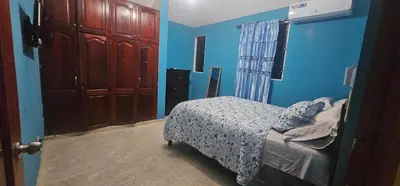 a bedroom with blue walls and a bed in a room at Paraíso en Repúblico Dominicana in Santiago de los Caballeros