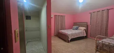 a bedroom with pink walls and a bed in a room at Paraíso en Repúblico Dominicana in Santiago de los Caballeros