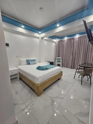 a bedroom with a bed and a table in it at Hotel Gutz in San Felipe de Puerto Plata